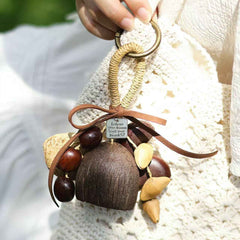 Handmade boho style fruit shell wind chime and shaker DIY kit hanging on a bag, perfect for sound healing and organic home decor.