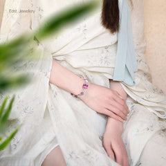 Handmade crystal jewelry featuring a premium amethyst and clear quartz beaded bracelet worn on a wrist.