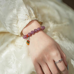 AURA LITH purple and pink crystal bracelet worn on a wrist to soothe stress and shield your aura from negative energy.