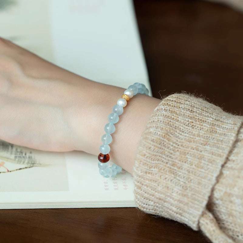 AURA LITH blue and yellow crystal bracelet worn on a wrist to help relieve stress and shield your aura from negative energy.