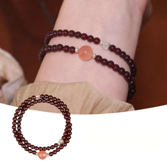 Handmade crystal jewelry featuring a premium carnelian and garnet beaded bracelet in single wrap style on a wearer's wrist.