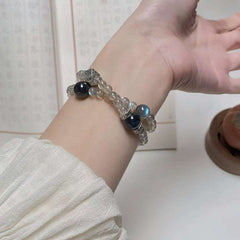 Close-up look of genuine 7A grade smoky quartz stones and protective obsidian beads from AURA LITH cosmic protection jewelry.