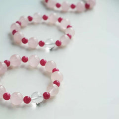 Close-up look of genuine 7A grade rose quartz beads and pink rhodonite stones from AURA LITH cosmic jewelry.