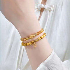 Handmade crystal jewelry featuring a premium rutilated quartz beaded bracelet worn on a wrist for leadership energy.