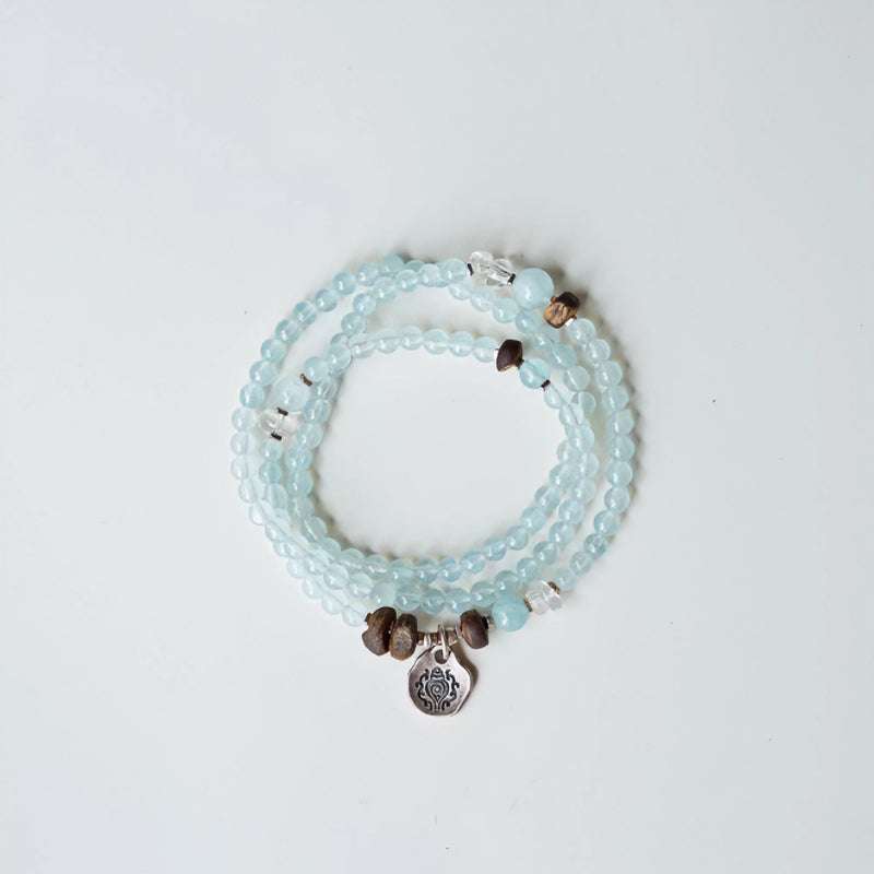 Handmade crystal jewelry featuring premium aquamarine crystals and sacred agarwood beads to support emotional healing.