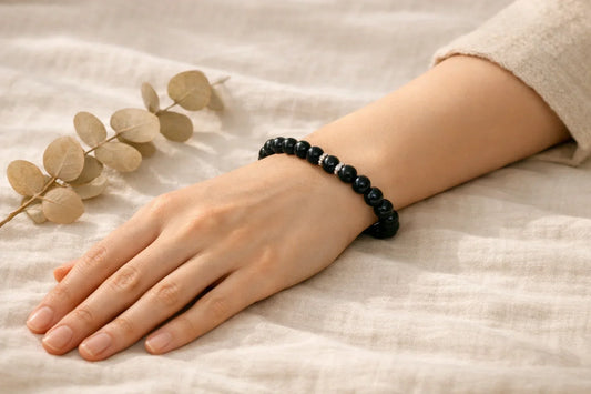 A close-up of a model wearing natural crystal healing bracelets by AURA LITH