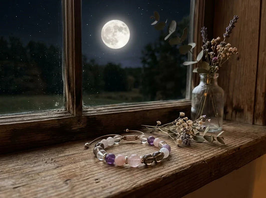 AURA LITH natural crystal bracelet resting on a wooden windowsill at night for full moon cleansing ritual.