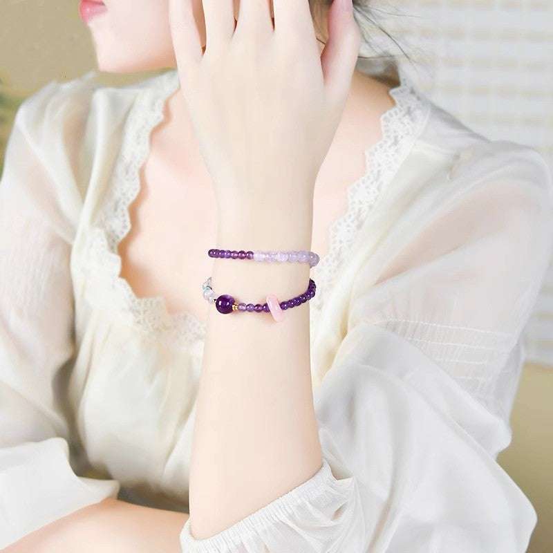 Handmade crystal jewelry featuring a premium amethyst and fluid aquamarine beaded bracelet worn on a wrist.