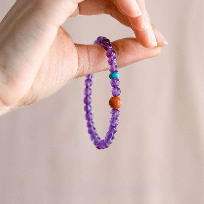 AURA LITH purple crystal bracelet worn on a wrist for cosmic protection and calming restless thoughts.