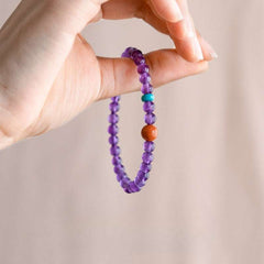AURA LITH purple crystal bracelet worn on a wrist for cosmic protection and calming restless thoughts.