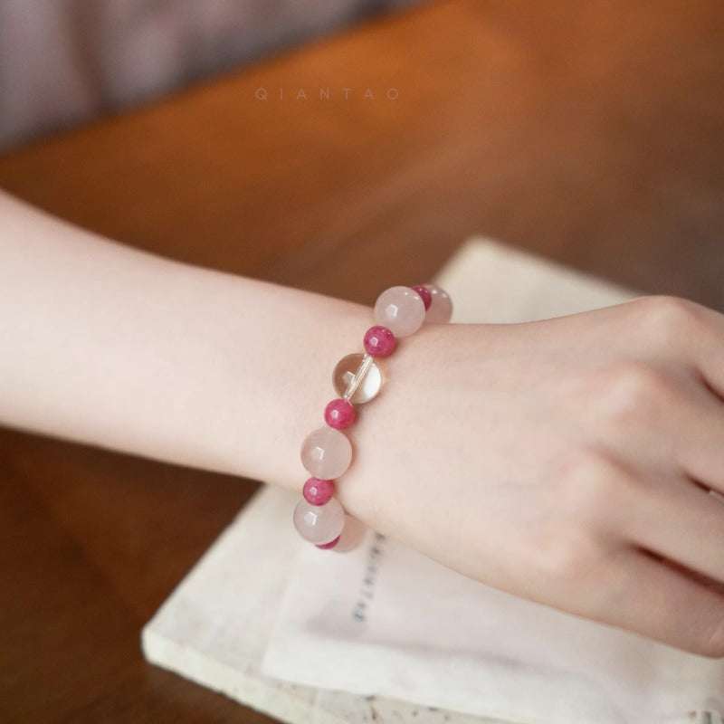 AURA LITH healing pink crystal bracelet worn on a wrist for deep inner harmony and shielding your aura.