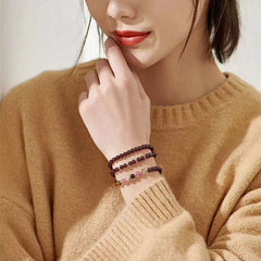 Handmade crystal jewelry featuring premium garnet and protective tourmaline beaded bracelet worn on a wrist.