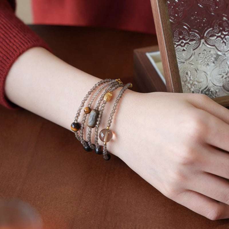 AURA LITH brown and black crystal bracelet worn on a wrist for shielding your aura and welcoming alignment.