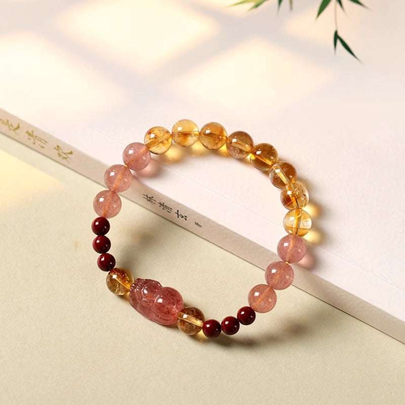 Close-up look of genuine citrine stones and a sacred gold PiXiu charm for prosperity by AURA LITH.