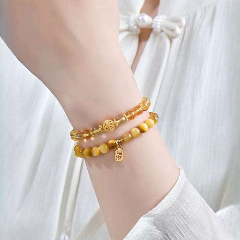 Handmade crystal jewelry featuring a premium rutilated quartz beaded bracelet worn on a wrist for leadership energy.