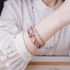 Handmade crystal jewelry featuring a premium strawberry quartz and rose quartz beaded bracelet worn on a wrist.