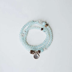 Handmade crystal jewelry featuring premium aquamarine crystals and sacred agarwood beads to support emotional healing.