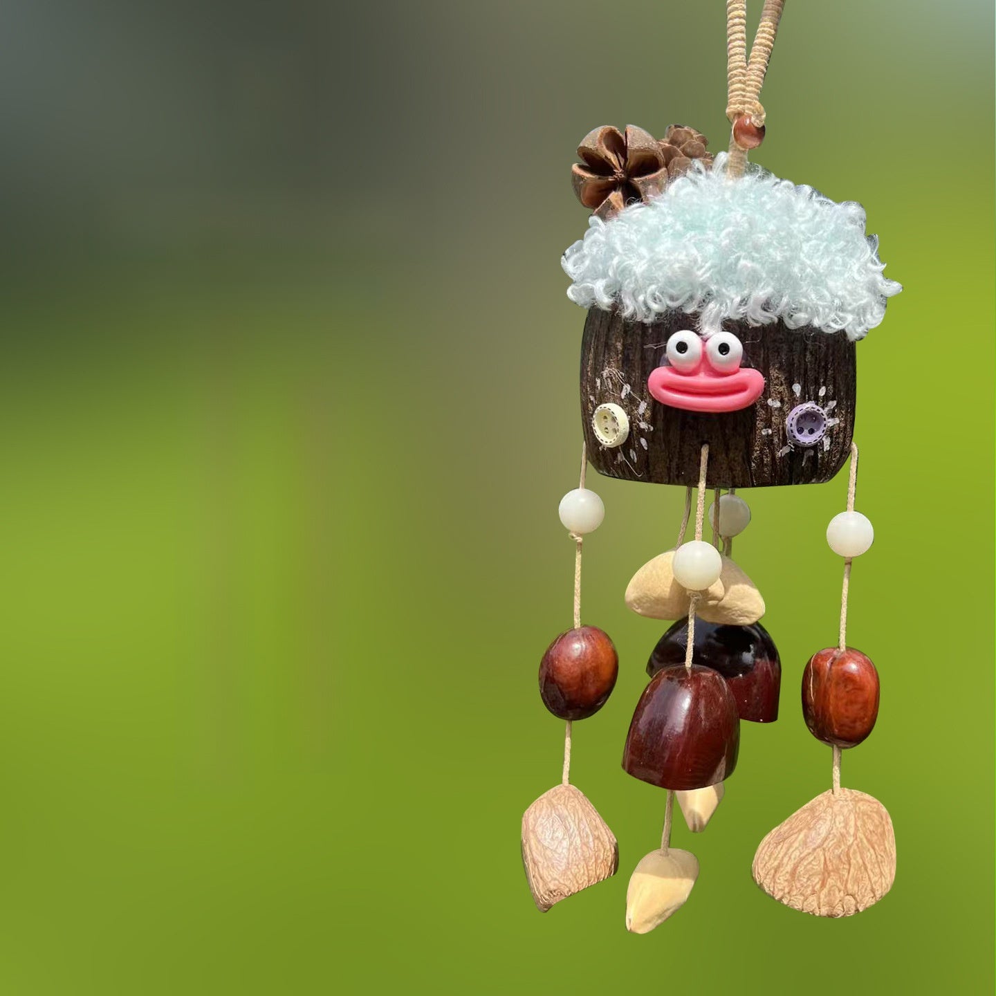 Handcrafted natural seed pod wind chime featuring a cute face design, unique boho-style hanging decor for sound healing and mindful home spaces.