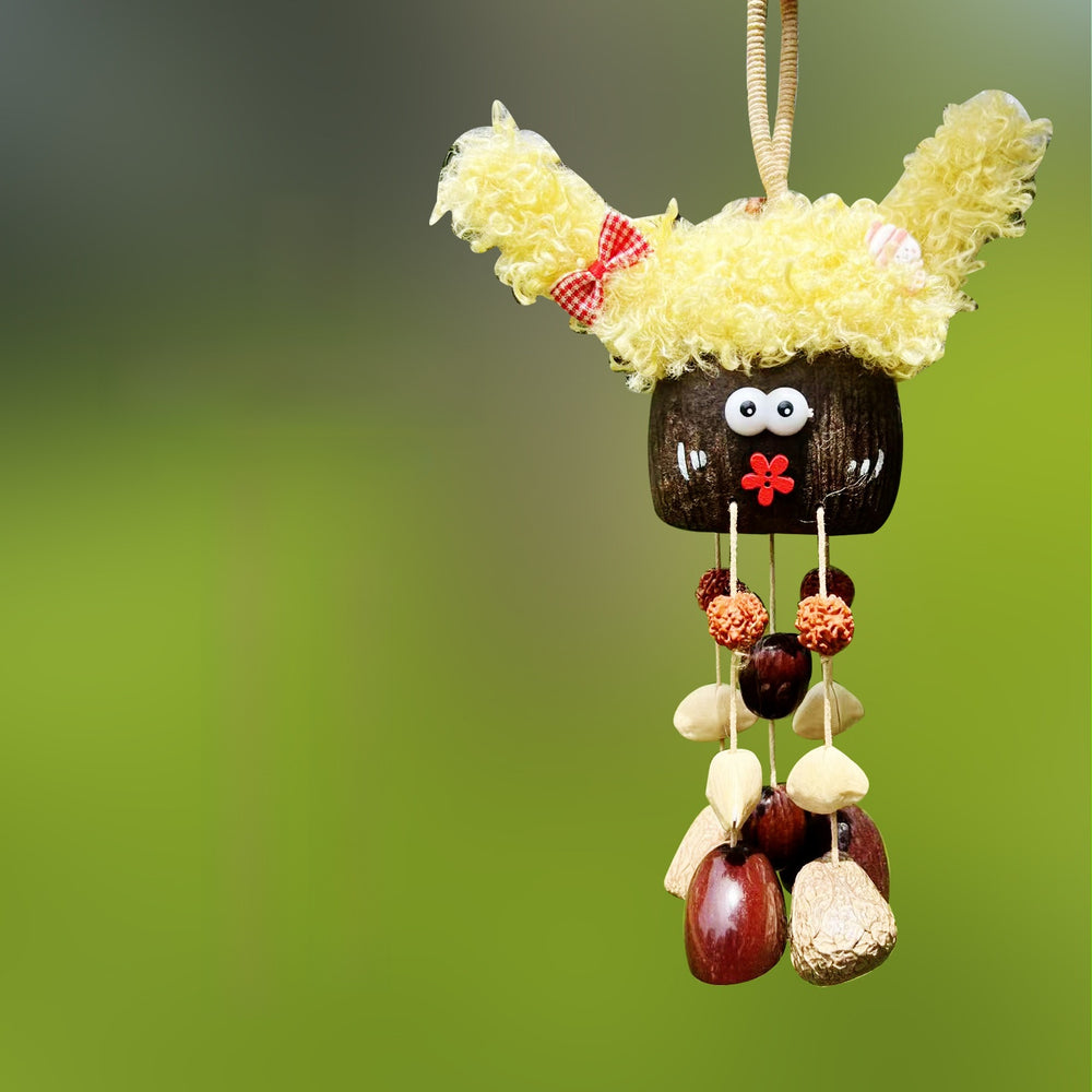 Handcrafted natural seed pod wind chime featuring a cute character shell with prominent yellow curly hair, googly eyes, and a small red painted flower mouth, unique boho hanging decor.
