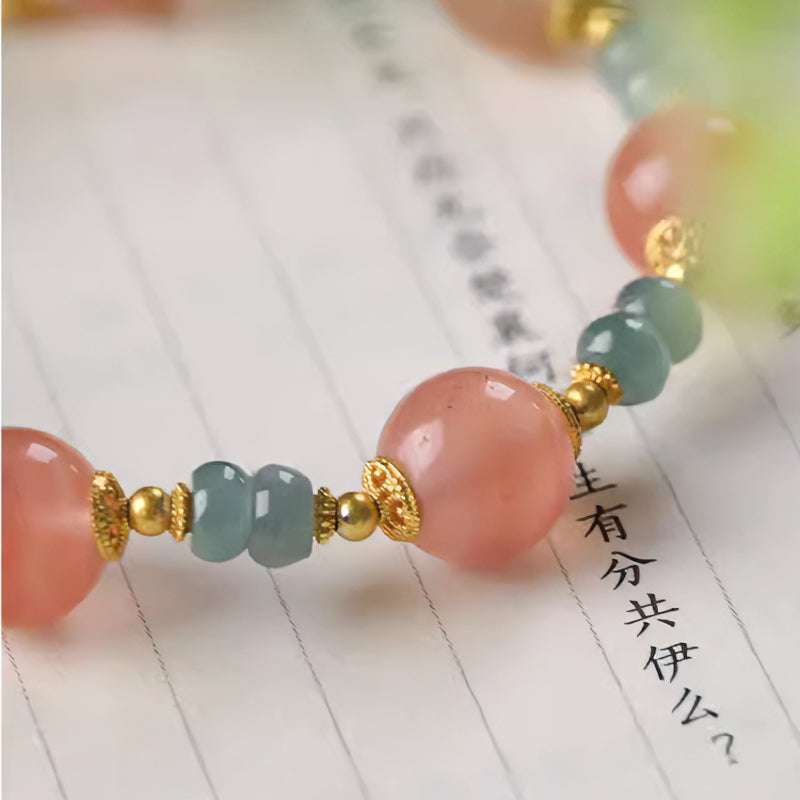 Close-up look of genuine ice southern red agate beads and protective serene jade from AURA LITH cosmic jewelry.
