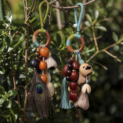Handcrafted natural seed pod wind chime with wooden beads and feather accents, boho-style home decor.